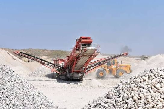 Mobile crushing and screening plant with a wheel loader at a quarry